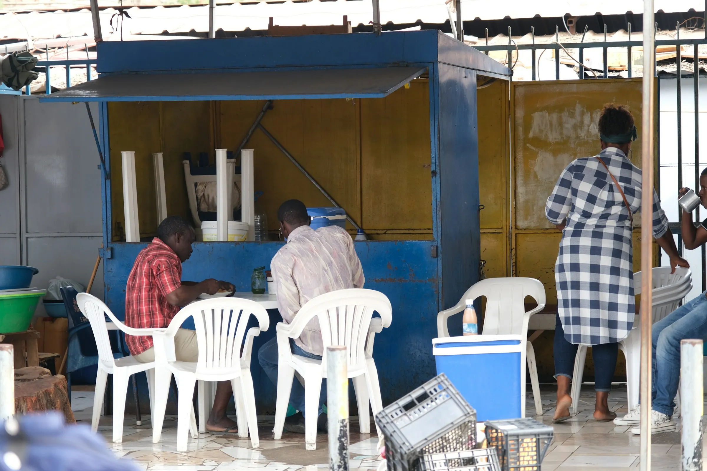 Customers seated at a roadside food kiosk in a township.