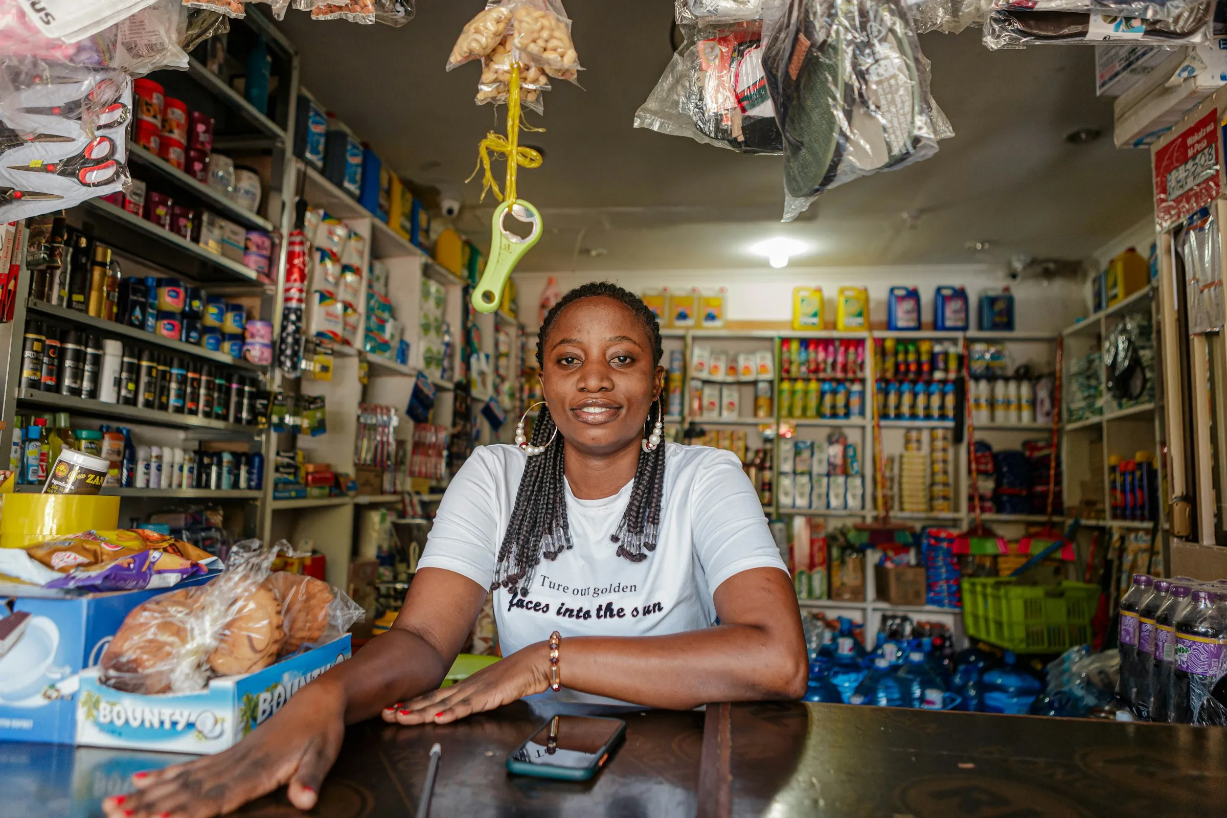 A shop owner at the counter of her spaza shop.